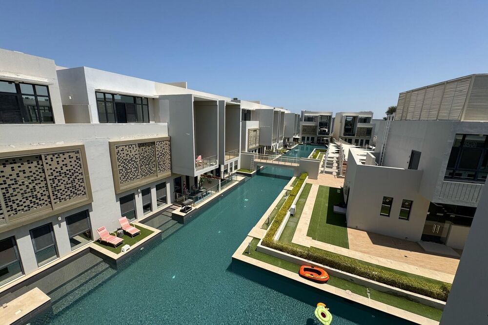 A managed villa compound in Bosher: mashrabiya screens along a courtyard swimming pool.